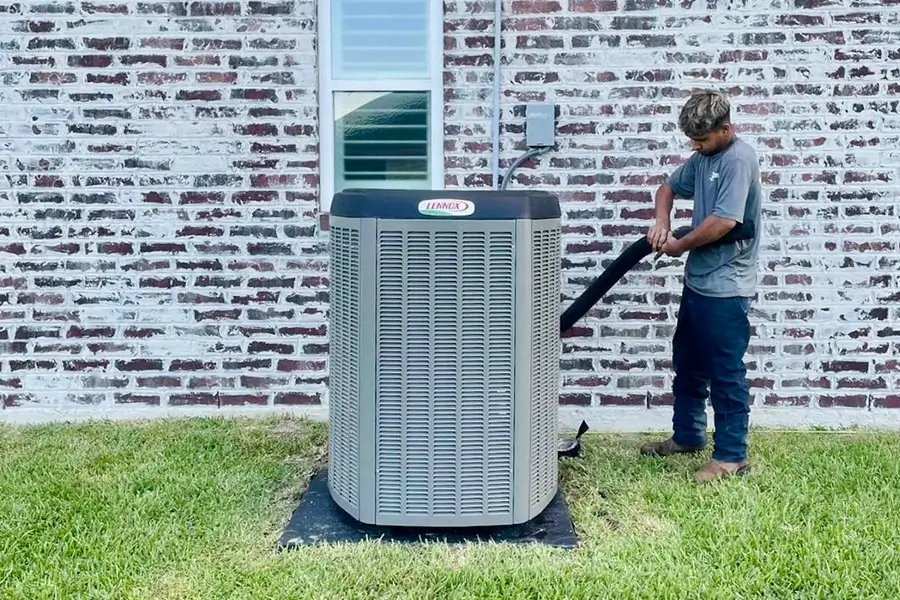Innovative Air Solutions technician installing AC unit beside home in Orange TX